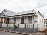 A charming city cottage positioned on one of...