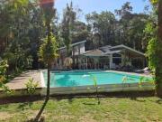 Casa em meio à natureza com um grande jardim e lago em...