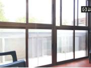 Habitación íntima con estantería en piso compartido, Los...