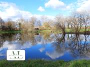 Terrain boisé avec étang, île et chalet en bois